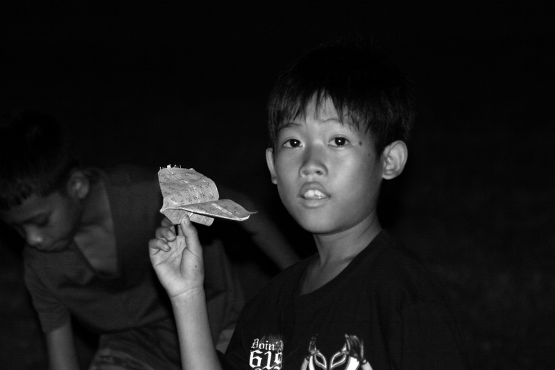 Boy with paper plane at a night market